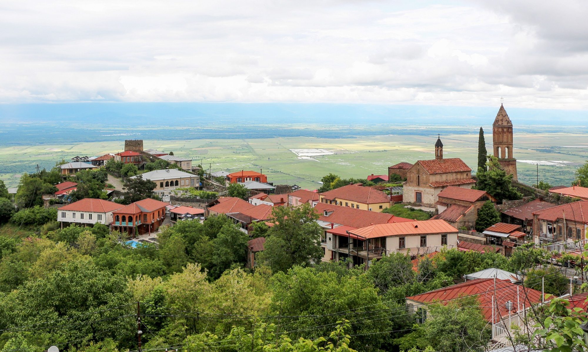 Daken en kerktoren van Sighnaghi met de Alazani-vallei in Kakheti