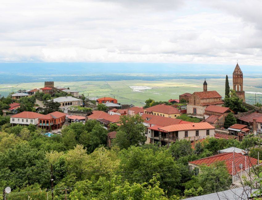 Daken en kerktoren van Sighnaghi met de Alazani-vallei in Kakheti